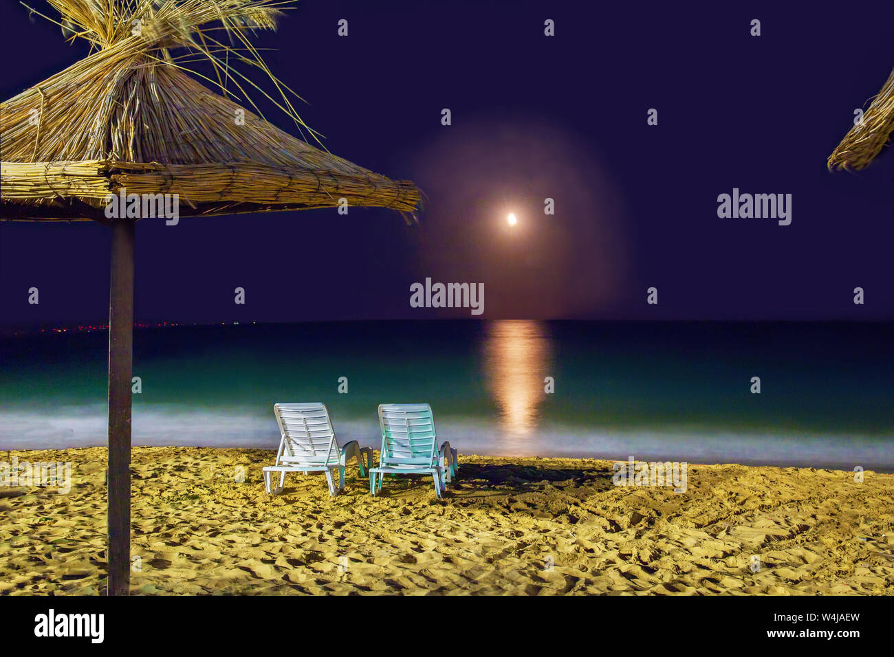 2 liegen in der Nähe von Wasser. Nacht am Strand. Warme Sommernächte für die Liebe. Golden Sands. Bulgarien. Subtropisches Klima Stockfoto