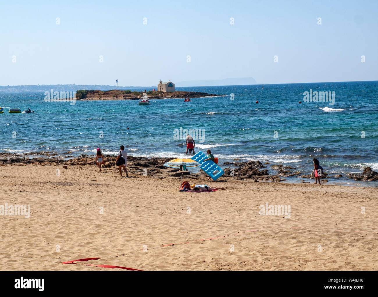 Malia, Kreta, Griechenland - Dezember 18, 2019: die Menschen ruhen auf einem sonnigen Tag am Strand in Malia, Kreta, Griechenland Stockfoto