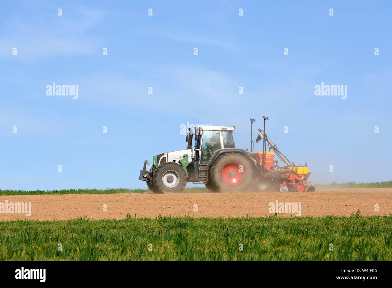 Traktor mit Sämaschine arbeitet ein Feld im Frühling, Baden-Württemberg, Deutschland Stockfoto