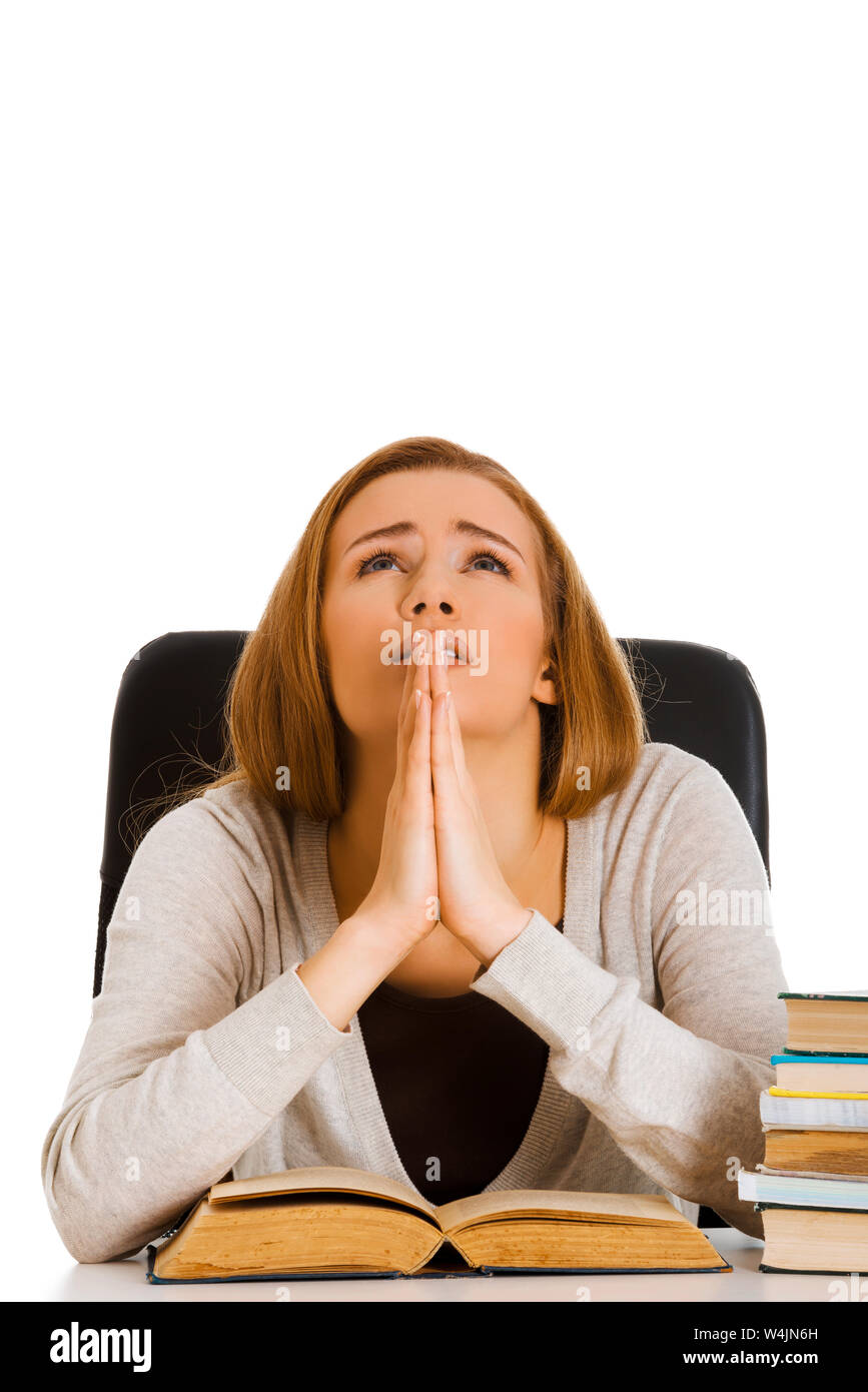 Junge erschrocken student Frau zu beten, während das Lernen über Bücher für den Test. Stockfoto