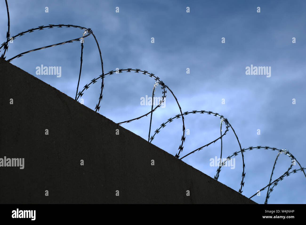 Silhouette von Concertina wire Perimeter an einer Wand Stockfoto