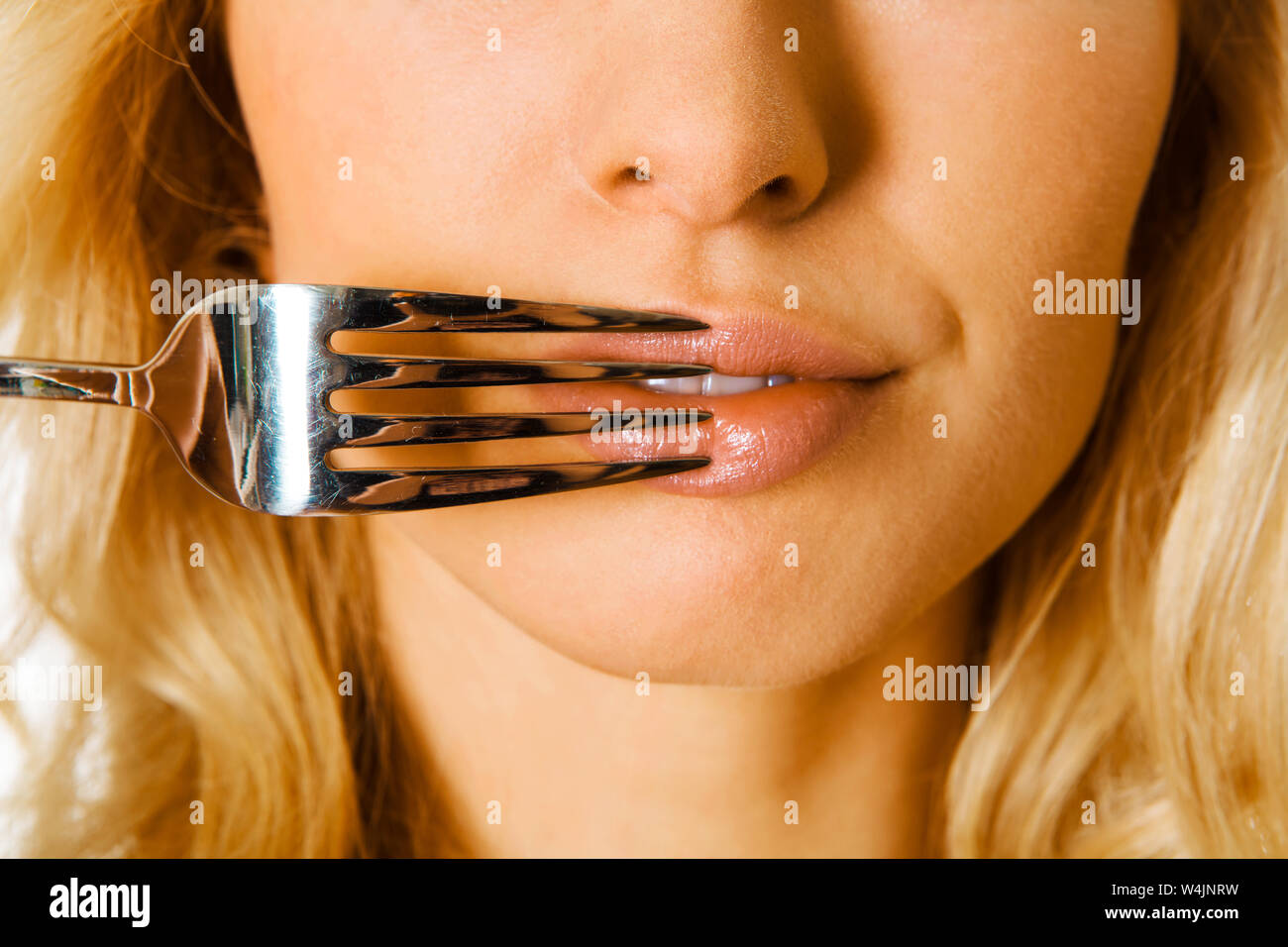 In der Nähe Blick auf Frau drücken Gabel an ihre Lippen. Gourmand Ernährung Konzept. Stockfoto