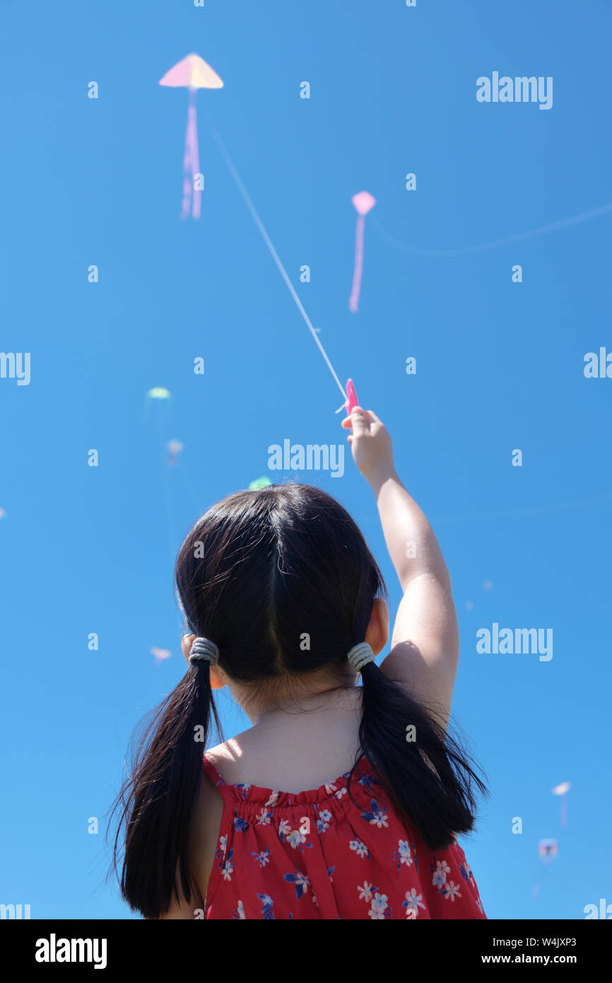 Kleines Mädchen flying a Kite in sonnigen Sommertag Stockfoto