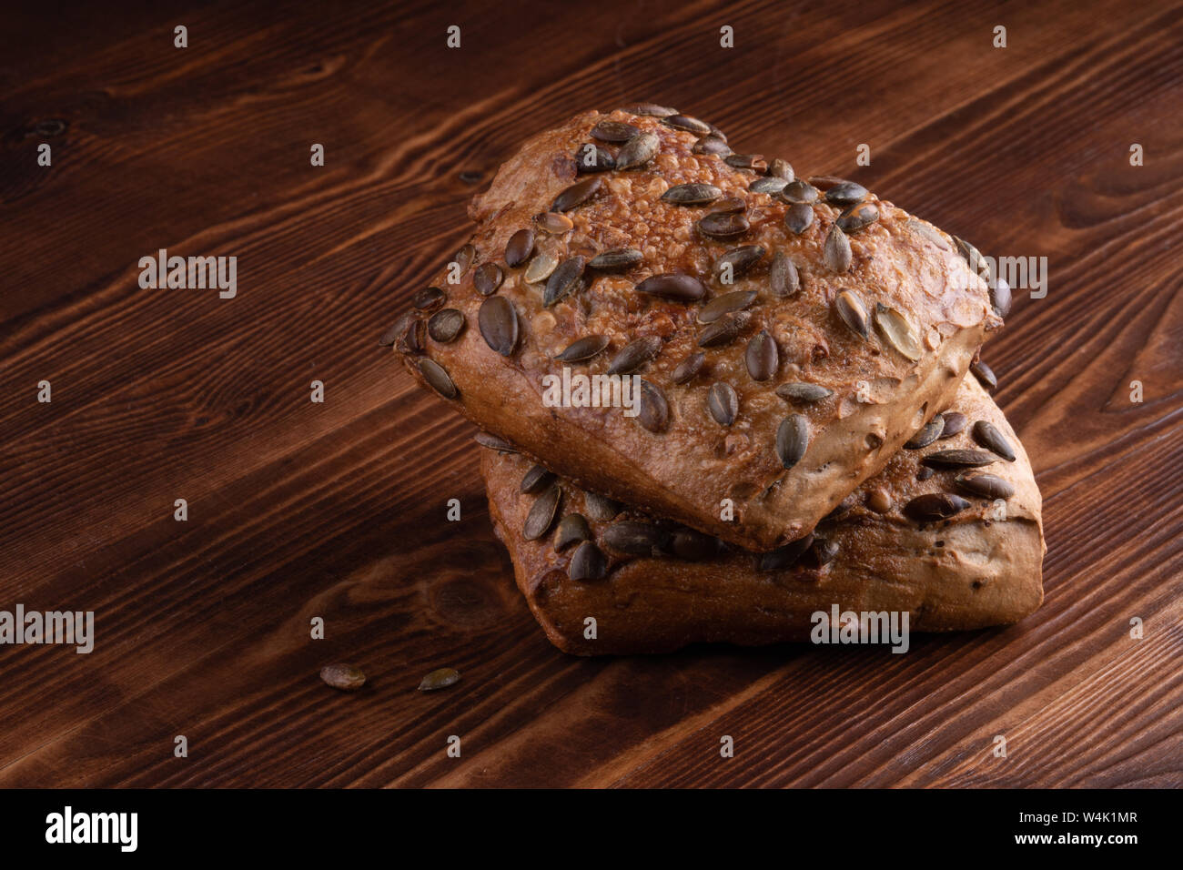 Roll Brot mit Kürbiskernen auf einer hölzernen Hintergrund Stockfoto