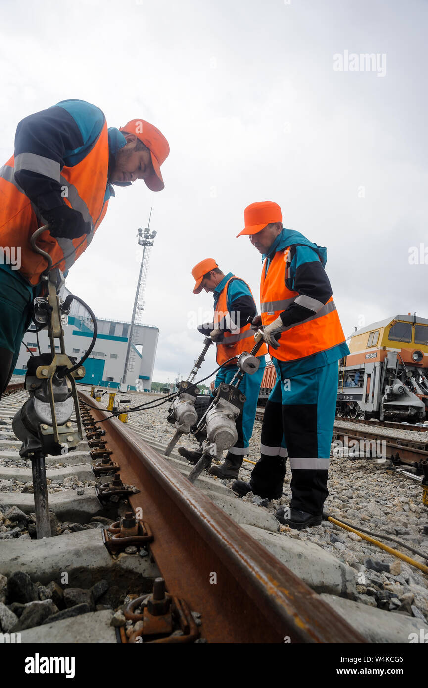 Tobolsk, Russland - 15. Juli. 2016: Sibur unternehmen. Denisovka Bahnhof. Eisenbahner Instandsetzung Rail im regnerischen Wetter Stockfoto