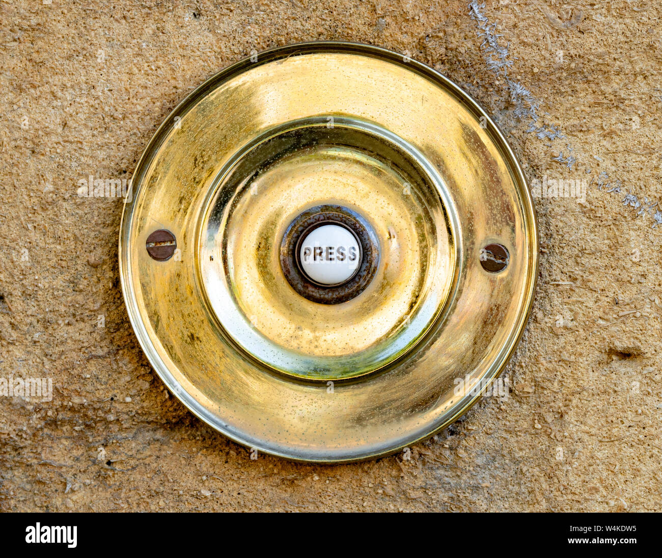 Eine kreisförmige Messing Tür Klingeltaster in Chipping Campden, Cotswolds, Gloucestershire, England, Vereinigtes Königreich, England, GB, UK. Stockfoto
