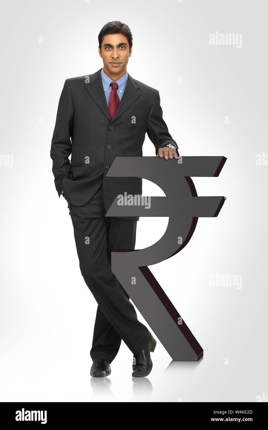 Geschäftsmann steht mit Rupie-Symbol Stockfoto