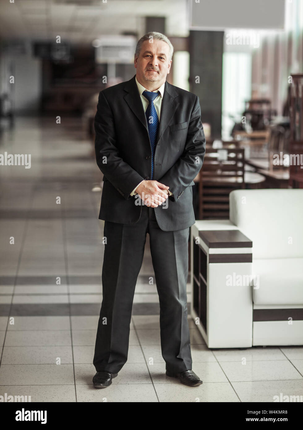 Erfolgreicher Geschäftsmann im Anzug auf dem Hintergrund der modernen Büro Stockfoto