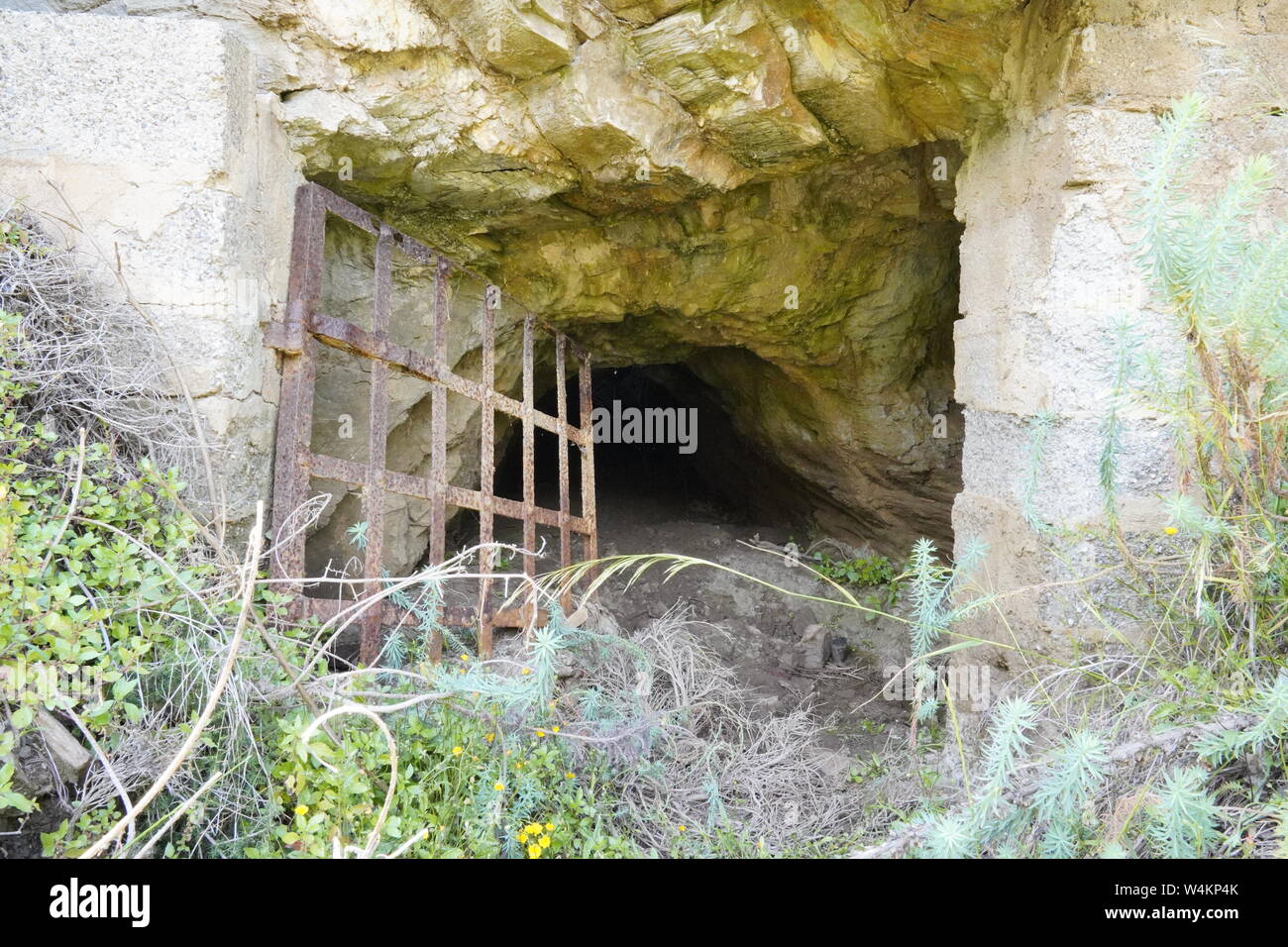 Verlorene Orte, rostige Gitter Barriere vor einer Höhle in Argientiera Stockfoto