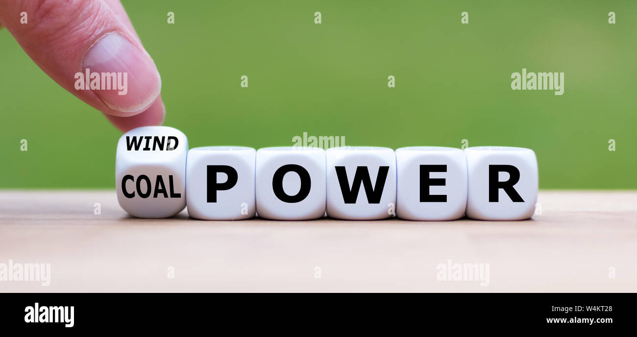 Hand, dreht sich ein Würfel und Änderungen der Ausdruck "Kohle" zu "Windenergie". Stockfoto
