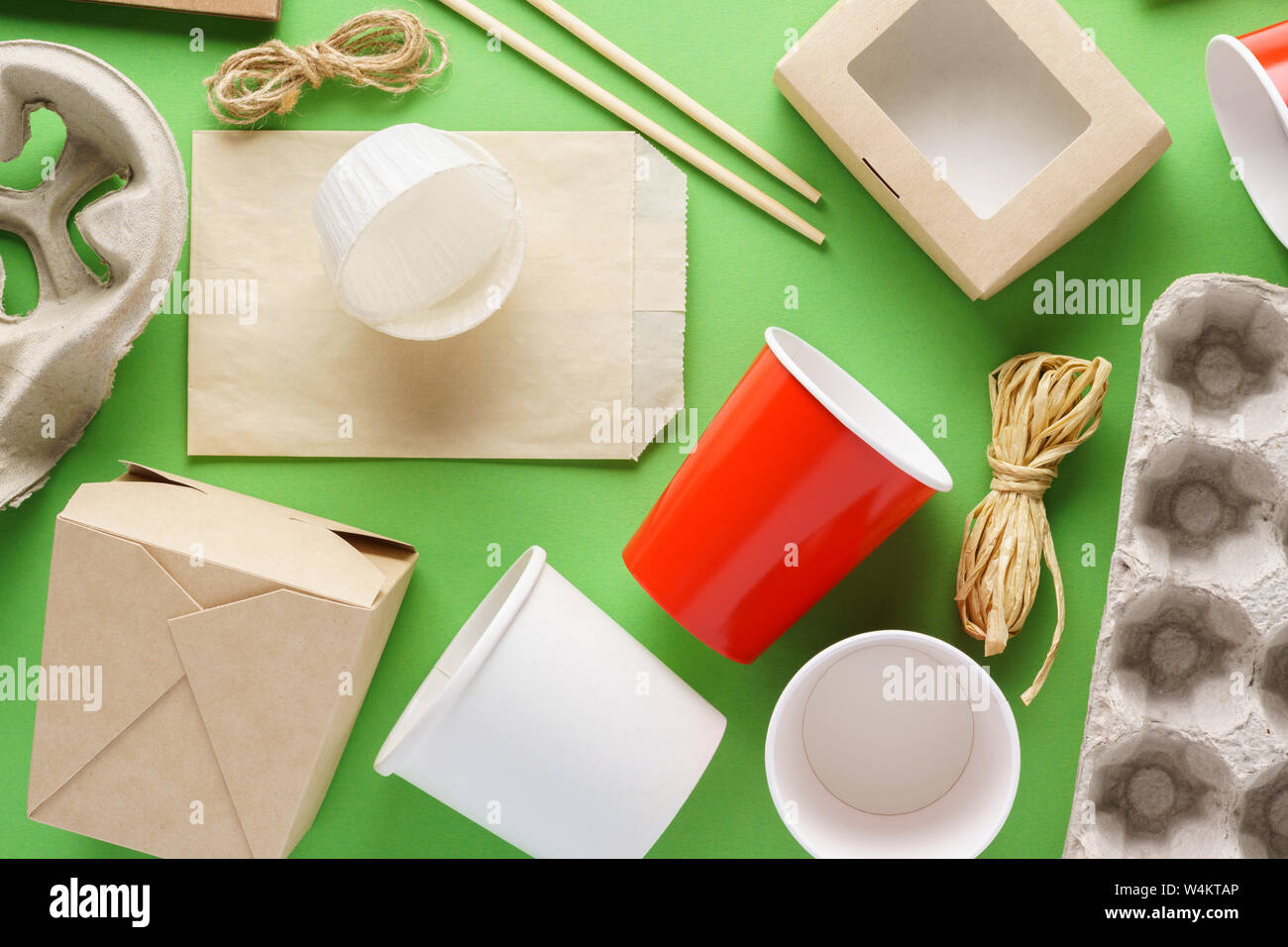 Einstellen der verschiedenen umweltfreundlichen Einwegverpackungen und Container auf grünem Hintergrund. Stockfoto