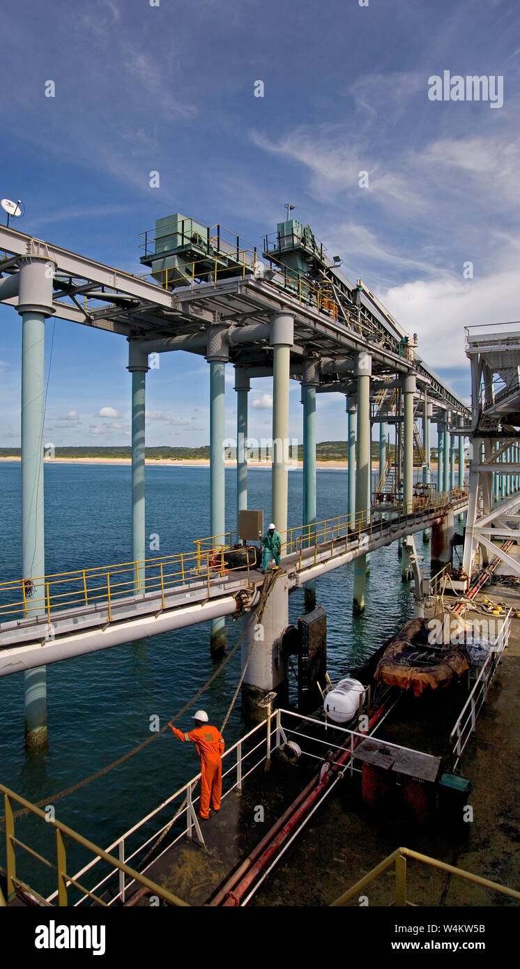 Bergbau, Verwaltung und Transport von Titanmineralsanden. Von beladenem Lastkahn, der aus Schiffsstegen mit Produkt zum Entladen in OGV auf See abführt Stockfoto