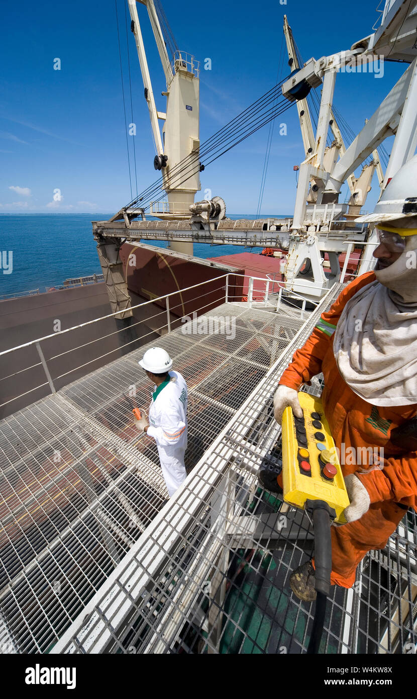 Bergbau, Verwaltung und Transport von Titanmineralsanden. Umschlagbarge neben OGV auf See mit Lagerungsschein für Mineralprodukte unten Stockfoto