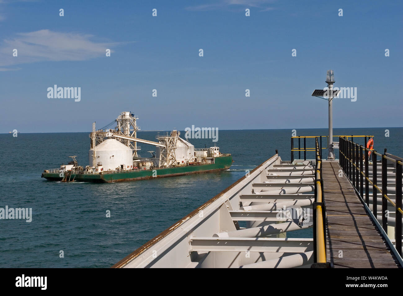 Bergbau, Verwaltung und Transport von Titanmineralsanden. Maßgeschneiderte Lastkahn, die nach dem Entladen des Produkts in OGV auf See am Hafen anlandt. Stockfoto