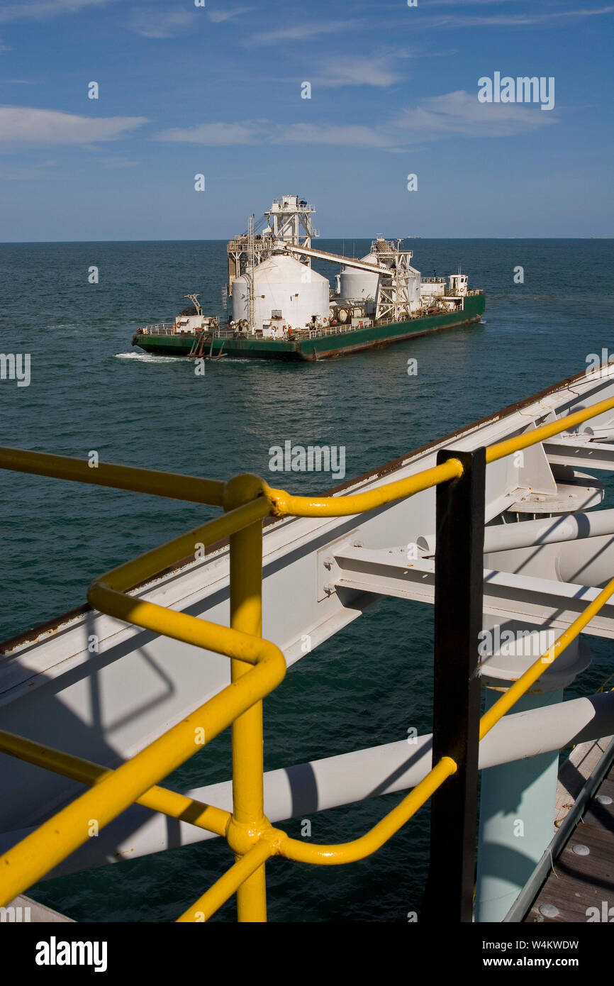 Bergbau, Verwaltung und Transport von Titanmineralsanden. Maßgeschneiderte Lastkahn, die nach dem Entladen des Produkts in OGV auf See am Hafen anlandt. Stockfoto