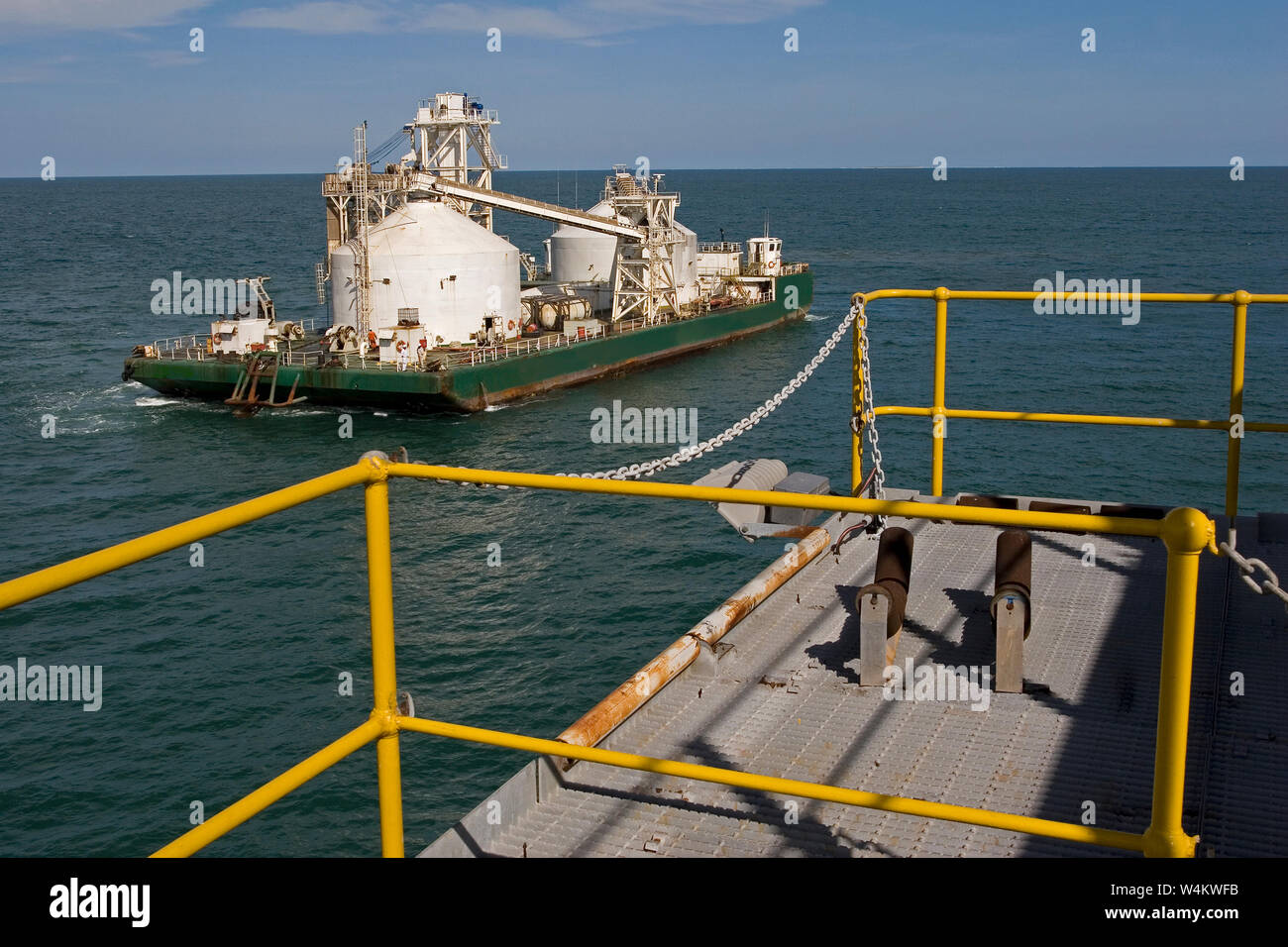 Bergbau, Verwaltung und Transport von Titanmineralsanden. Maßgeschneiderte Lastkahn, die nach dem Entladen des Produkts in OGV auf See am Hafen anlandt. Stockfoto