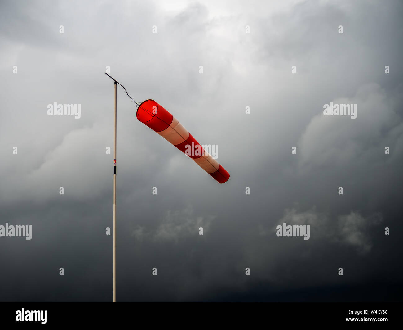 Windsack Rot auf Schwarz stürmischen Himmel. Schlechtes Wetter, meteorologischen Windanzeiger. Stockfoto
