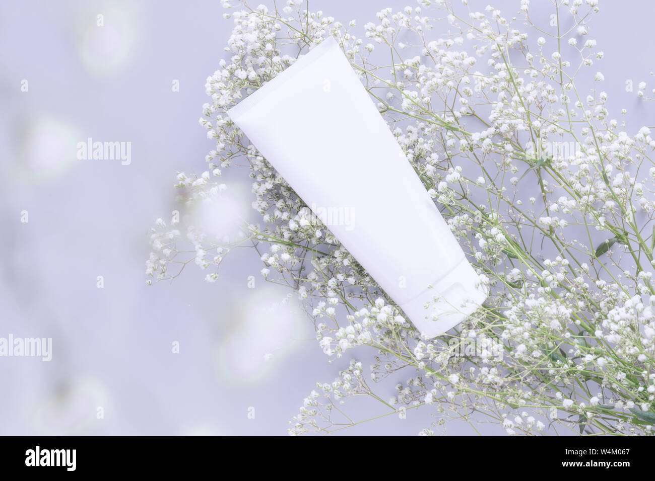 Kosmetischer Natur organische Hautpflege Kosmetik Konzept. Weiß in Weiß tube Container mit leeres Etikett für das Branding Verpackung mock up, mit Wh dekorieren Stockfoto