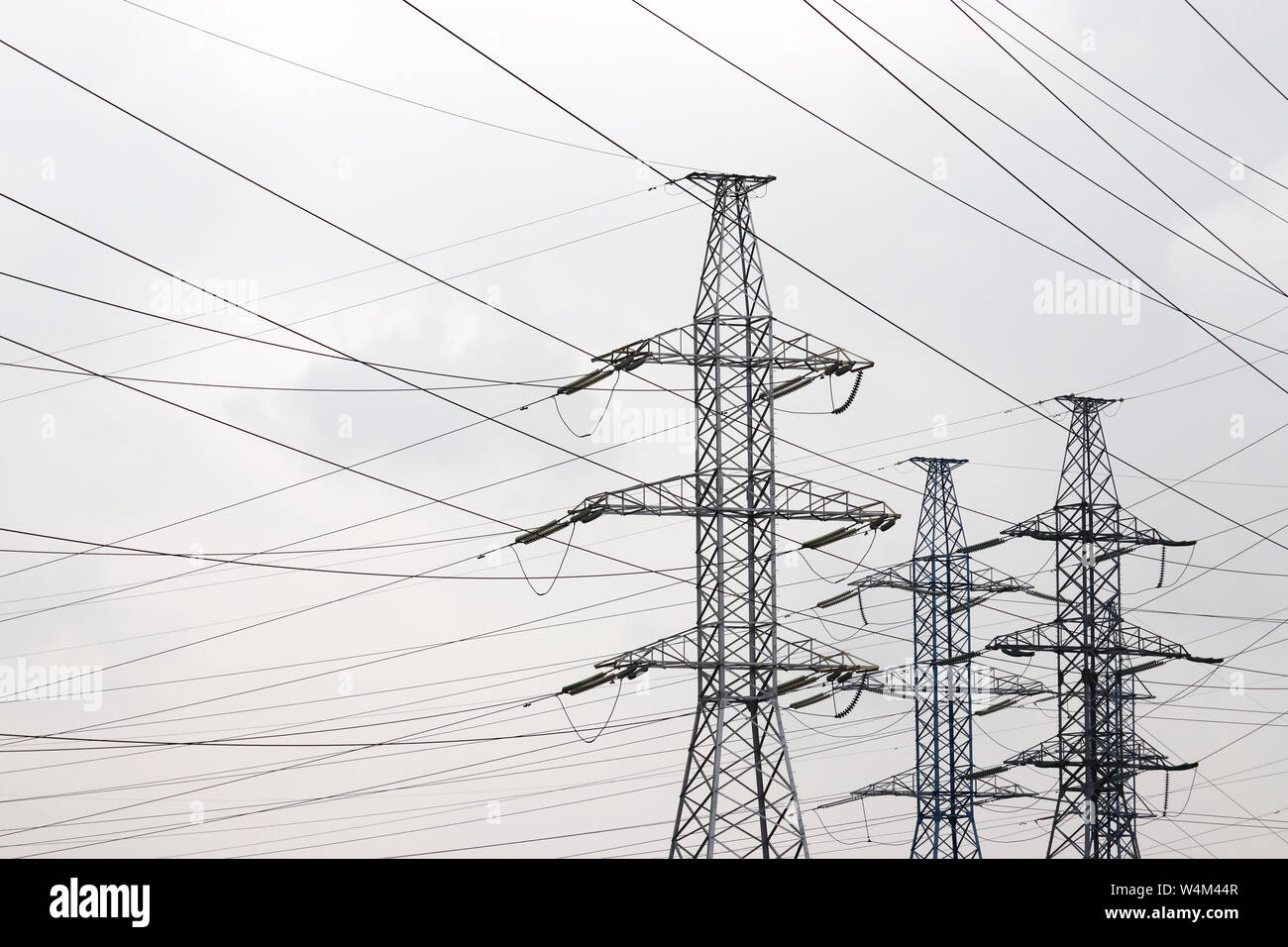 Hohe Spannung Turm mit elektrischen Leitungen an bewölkten Himmel Hintergrund. Fernleitungen, electric power station Stockfoto