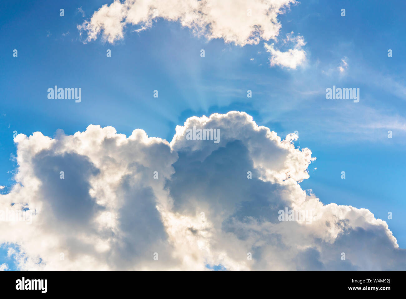 Großen blauen Himmel und große Wolken von den Strahlen der Sonne durchbohrt. Stockfoto