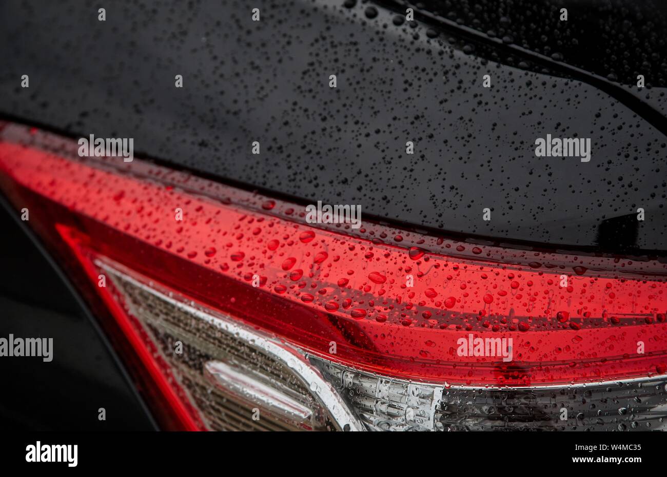 Regentropfen auf das Licht der schwarzen Auto Stockfoto