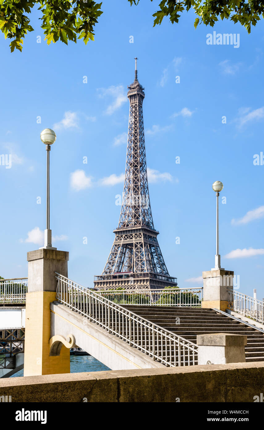 Der Eiffelturm in Paris, Frankreich, von der Bank, der Seine mit der Treppe und Straßenlaternen Der Debilly Fußgängerbrücke im Vordergrund gesehen. Stockfoto
