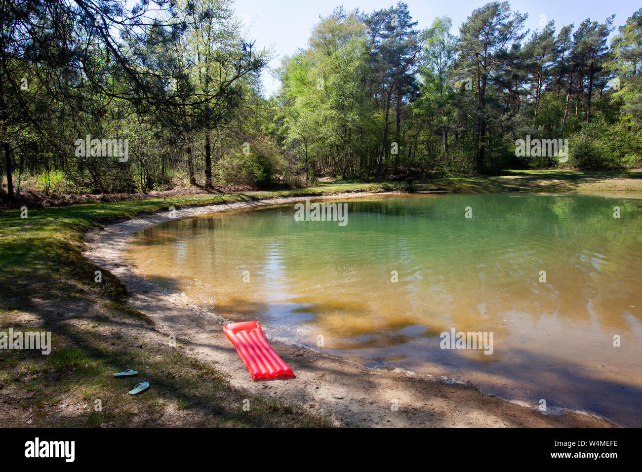 Red Luftmatratze und blauen Flip Flops in der Nähe einer fen in den Niederlanden Stockfoto