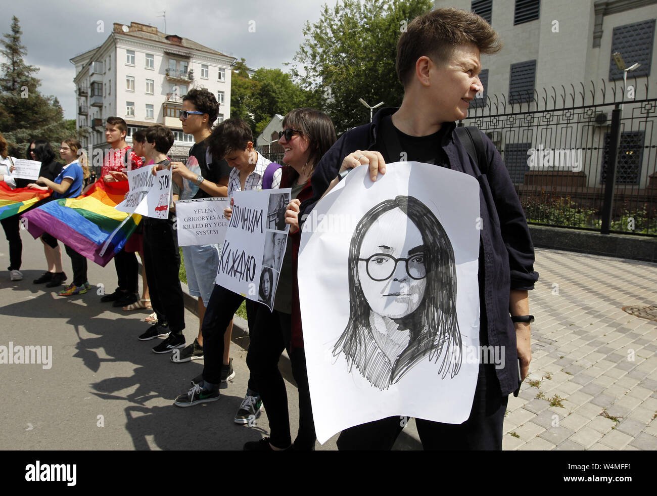 Kiew, Ukraine. 24. Juli, 2019. Ein Aktivist hält ein Plakat mit einem Bild von der LGBT-Rechte Aktivist Elena Grigoryeva, bei einer Rallye LGBT-Aktivisten mit der Nachfrage in Russland eine Untersuchung ihrer Ermordung, vor der Botschaft Russlands in Kiew, Ukraine, am 24. Juli 2019. Der 41-jährige LGBT-Rechte Aktivist Elena Grigoryeva tot war mit mehreren Schnittwunden in St. Petersburg in Russland am Sonntag, die von den Medien berichtet. LGBT-Rechte Aktivist Elena Grigorieva waren oft die Teilnahme an Kundgebungen von der Allianz der Heterosexuellen und LGBT-Bündnis und andere zivile Initiativen stattfinden, für den Rechten befürwortet Stockfoto