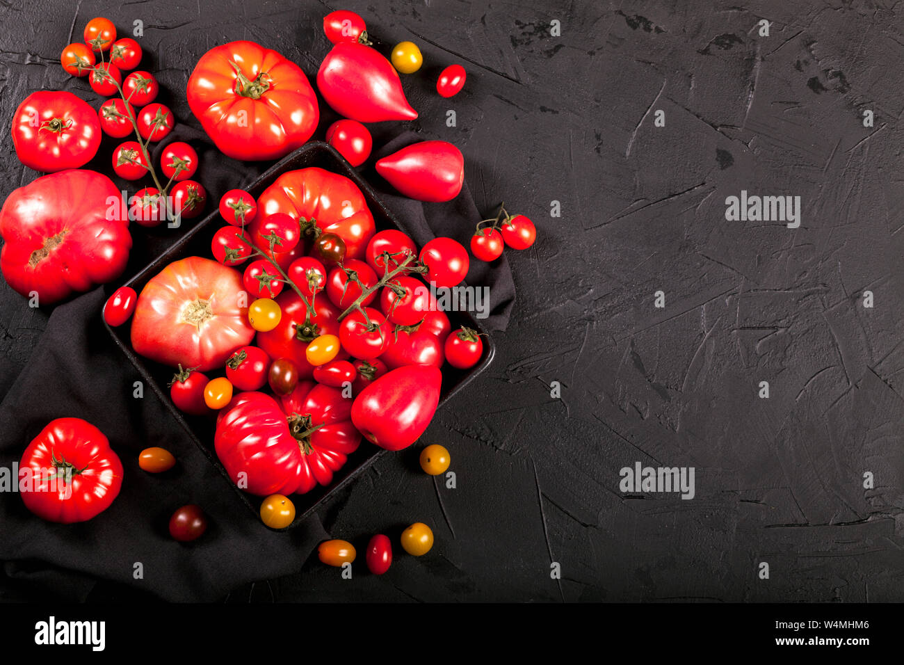 Tomaten auf schwarzem Hintergrund oben kopieren. Stockfoto