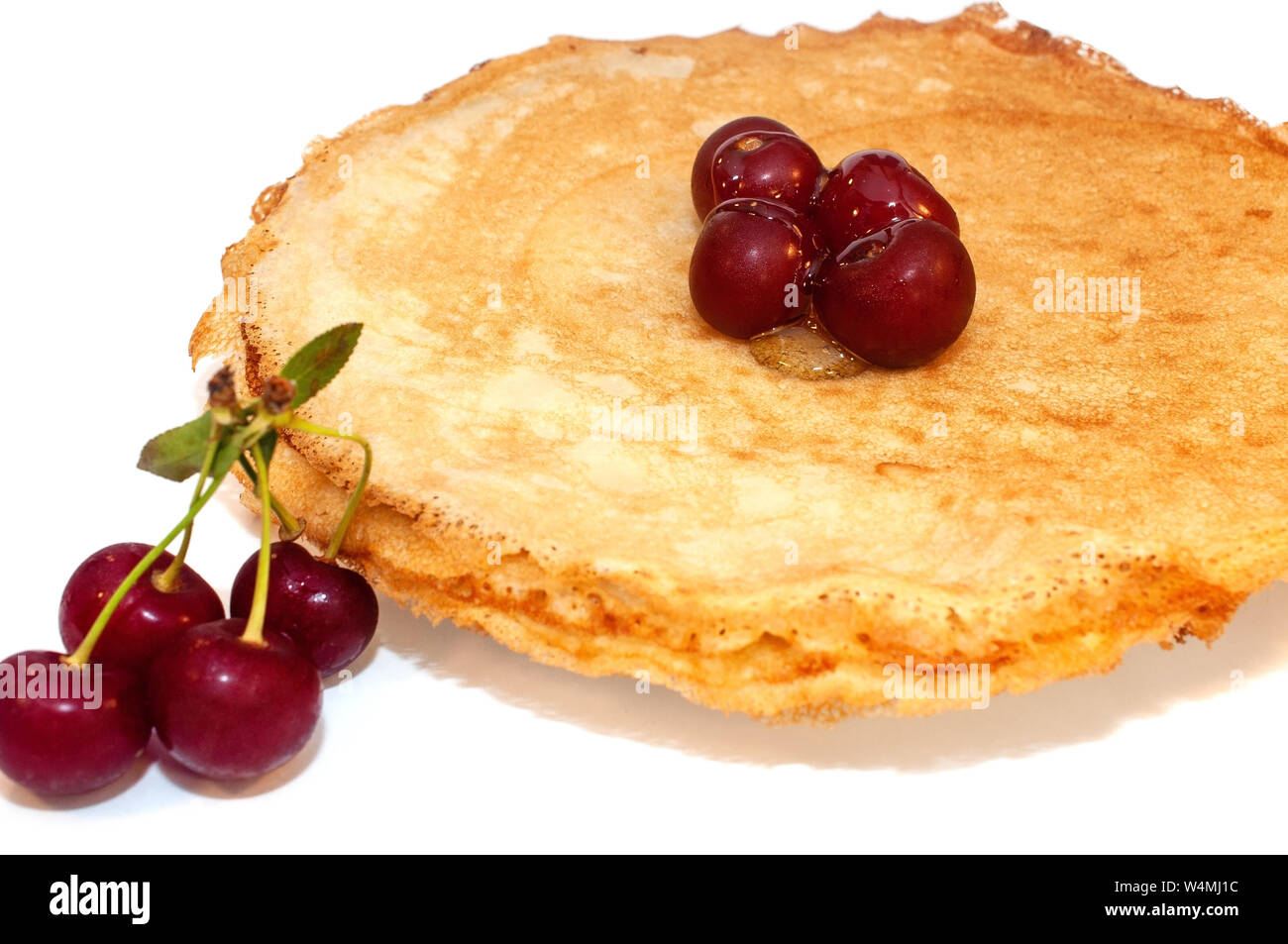 Pfannkuchen zum Frühstück mit Kirschen Beeren auf weißem Hintergrund Stockfoto