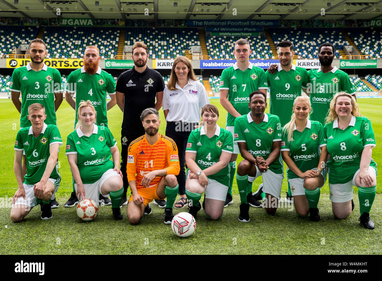 Spieler von den Nordirland Männer und Frauen obdachlos Fußballmannschaften, mit Justin McMinn (dritter von links an der hinteren Zylinderreihe) der Street Soccer NI, und Katherine Hill (vierter von in der hinteren Reihe links), der Leiter des aktiven Gemeinschaften an der Abteilung für Gemeinschaften auf, während ein fotoshooting an der National Stadium, Windsor Park, vor den Teams "Abflug morgen für den Homeless World Cup in Cardiff am kommenden Wochenende. Stockfoto