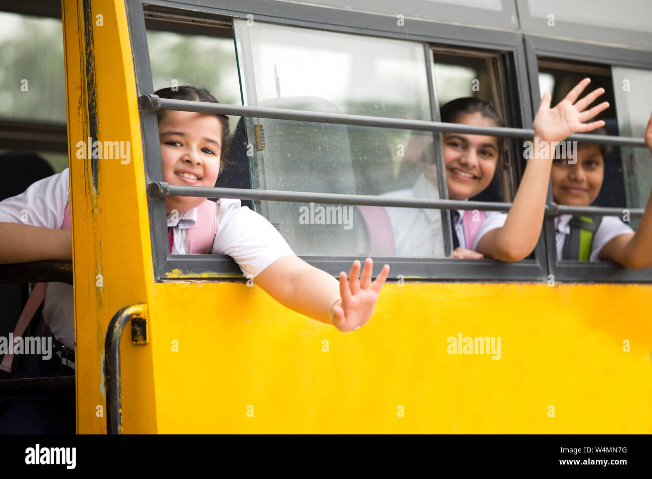 Happy Indian School Kinder Hand winken aus dem Fenster der Schule Bus Stockfoto