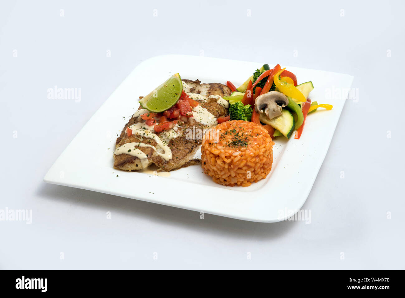 Ein Held geschossen von einem gegrillten Fisch Filet gratini mit Gemüse & Linsen auf der Seite, auf einem weissen Teller, minimalen Hintergrund mit einem 60 Grad nach vorne Stockfoto