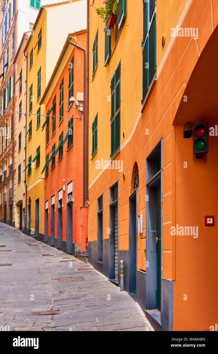 Perspektive der alten Straße bergauf mit gelb-orange malerischen Häusern in Genua (Genova), Italien Stockfoto