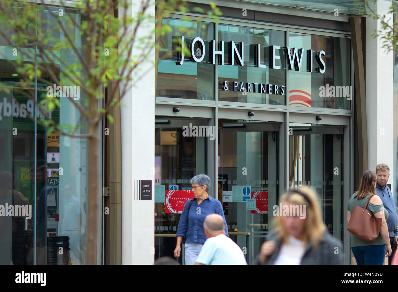 Massen von Käufern vorbei gehen. Die neue John Lewis und Partner Shop im Stadtzentrum von Cheltenham, Gloucestershire, Großbritannien Stockfoto