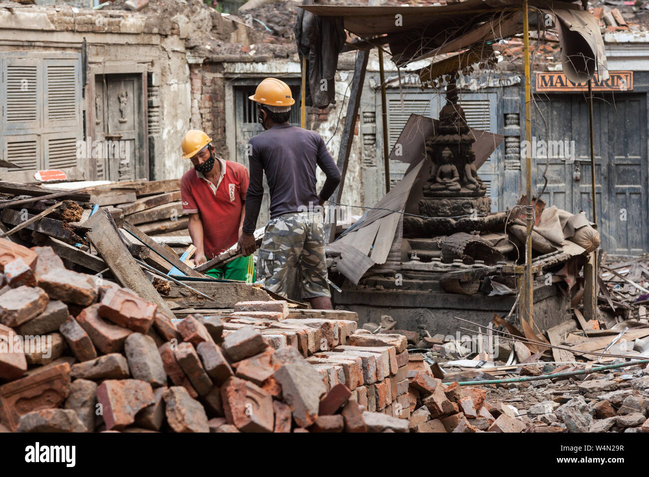 Männer Clearing die Website eines kleinen Tempels durch ein Erdbeben in Kathmandu beschädigt. Stockfoto