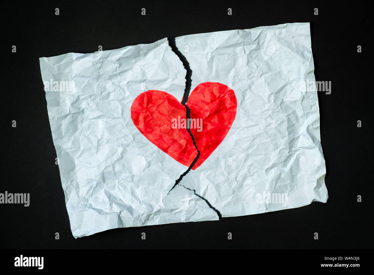 Gebrochenes Herz, Verlust, beendete Beziehung oder betrügen Konzept. Zeichen der Herzen mit einem Stift auf ein Stück zerbröckelt zerrissenes Papier gezeichnet. Stockfoto