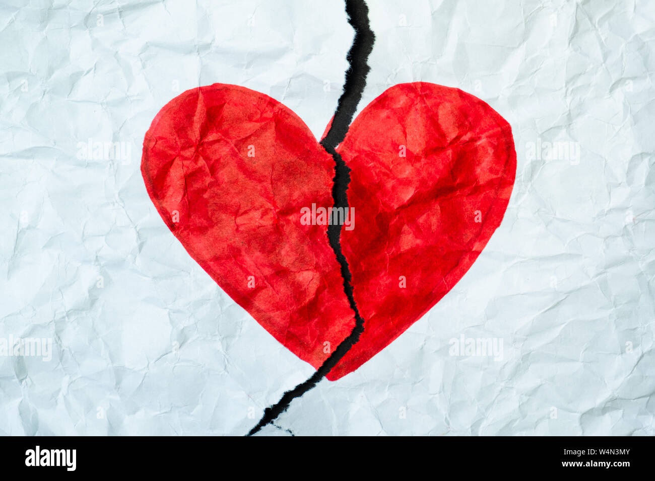Gebrochenes Herz, Verlust, beendete Beziehung oder betrügen Konzept. Zeichen der Herzen mit einem Stift auf ein Stück zerbröckelt zerrissenes Papier gezeichnet. Stockfoto