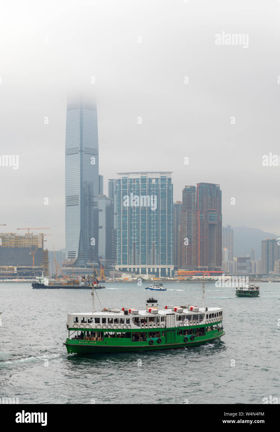 Star Ferry Verlassen der Zentralen Fährhafen auf der Insel Hong Kong mit International Commerce Center in Kowloon, Hongkong, China Stockfoto