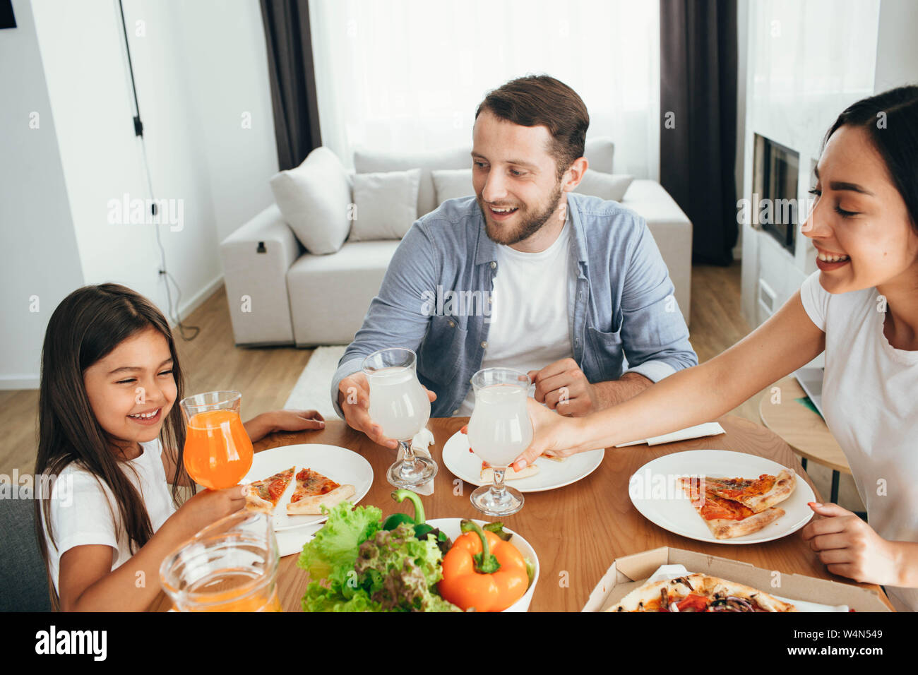 Familie, Mutter, Vater und Tochter beim Essen. Essen essen hausgemachte Pizza zu Hause Stockfoto