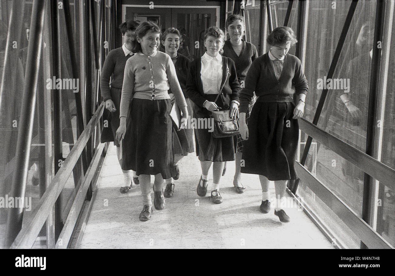 1950, historische, Gruppe der Schule Mädchen gehen durch eine Kreuzung zwischen Klassenzimmer an einer britischen Grafschaft Secondary School, England, UK. Stockfoto