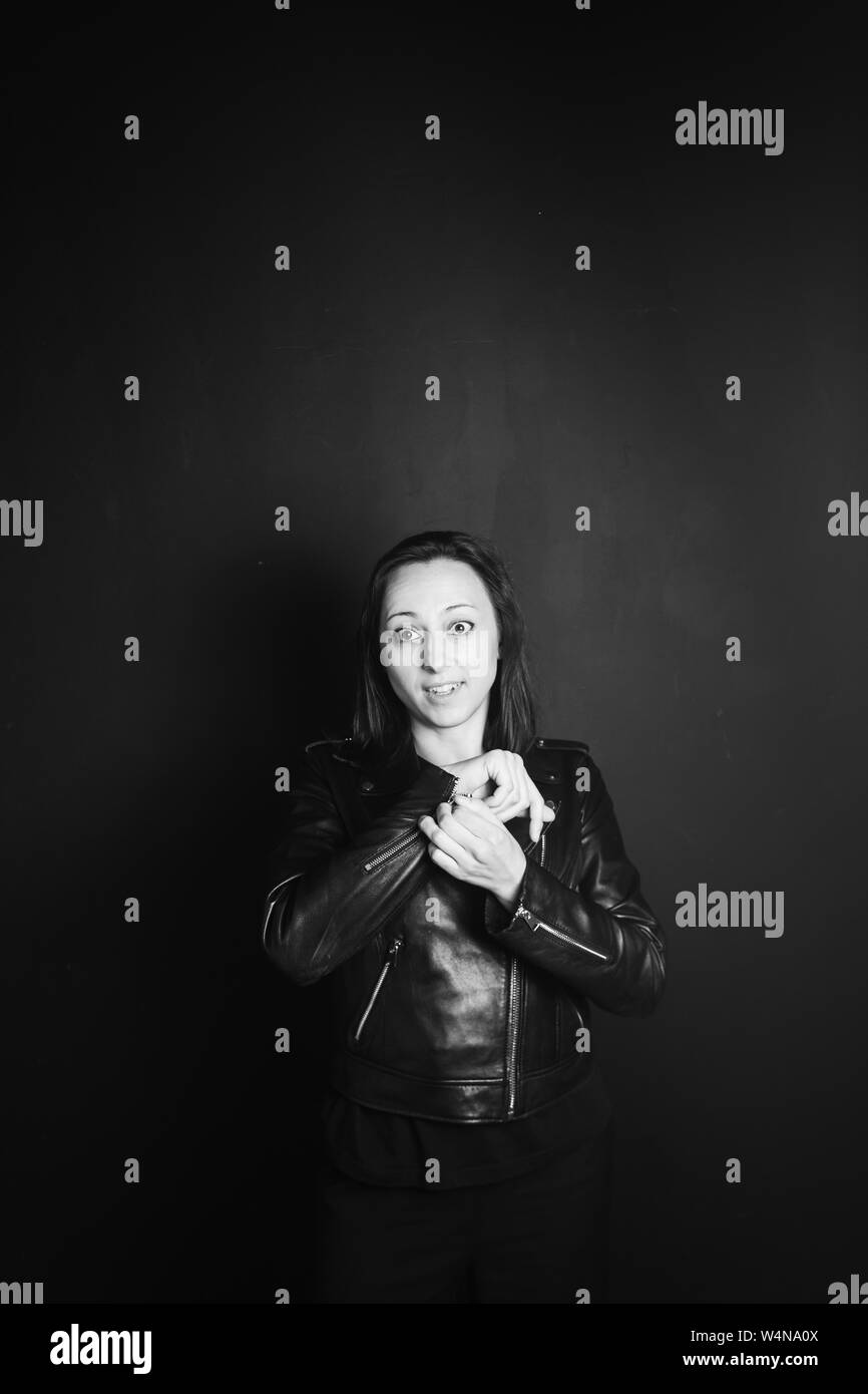 Studio Portrait einer attraktiven jungen Frau in schwarzem Leder Jacke gegen einen einfachen Hintergrund Stockfoto