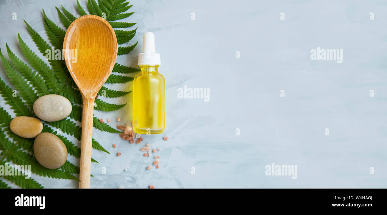 Spa noch Leben mit Öl Flasche, natürlichen botanischen Blick von oben auf die Spa mit Farn, Massage Steine, Löffel aus Holz mit Bio Öl und die Flasche, Stockfoto