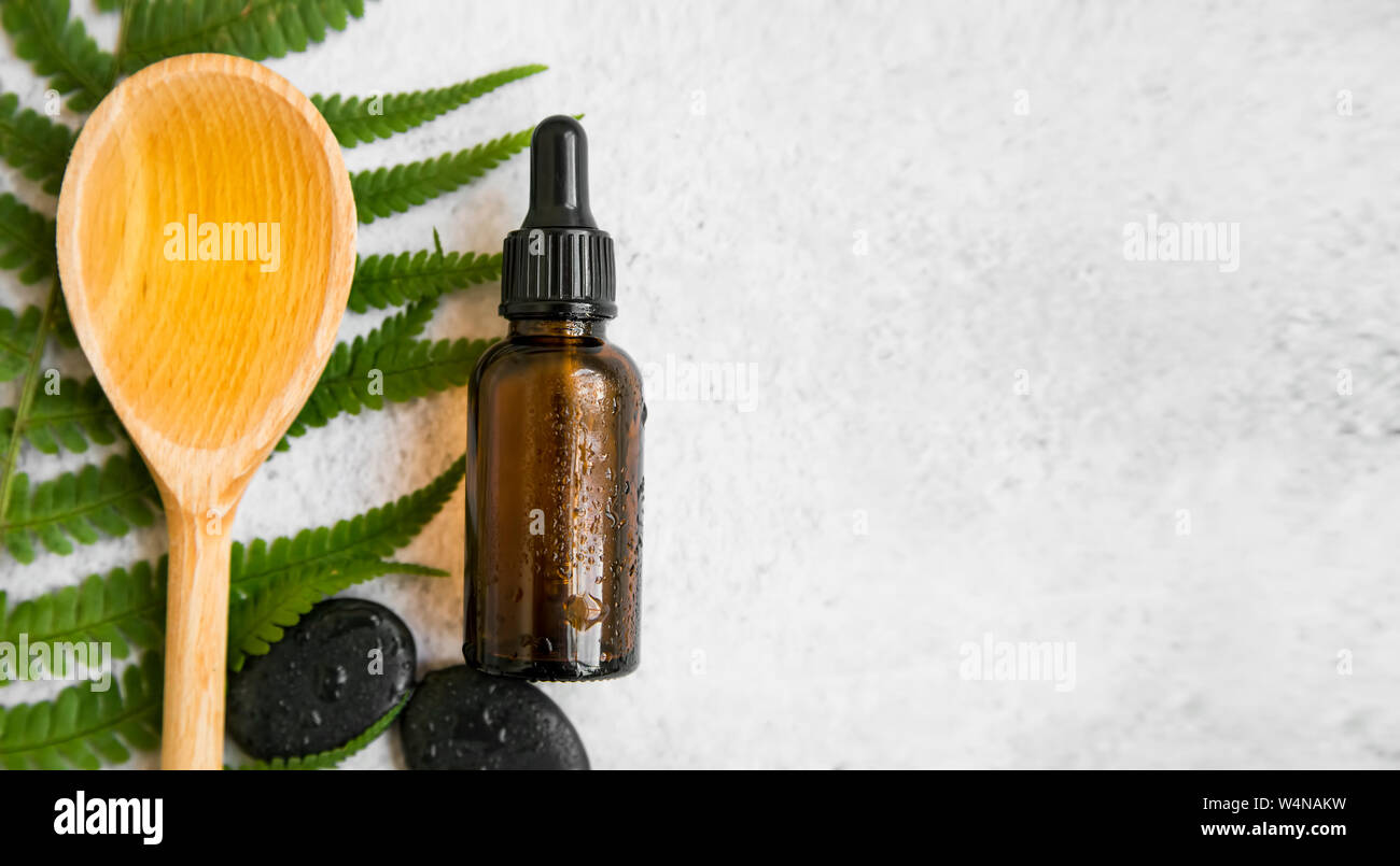 Spa Noch leben Nahaufnahme mit Öl Flasche, Massage Steine, Löffel aus Holz mit Öl und grünen Farn. Grün, botanische Spa flatlay, Natürliche Hautpflegeprodukte. Stockfoto