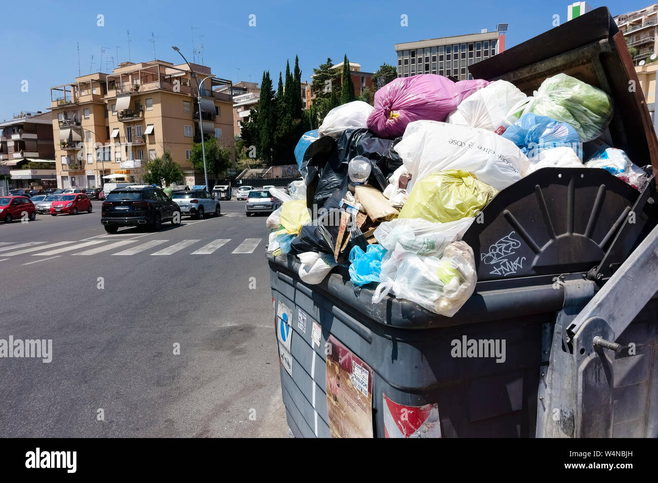 Papierkorb voll Abfall vor der Condominium Gebäude. Überquellenden Müll Müll container. Zivilisierung, Grobheit und Schmutz. Rom, Italien, Europa Stockfoto