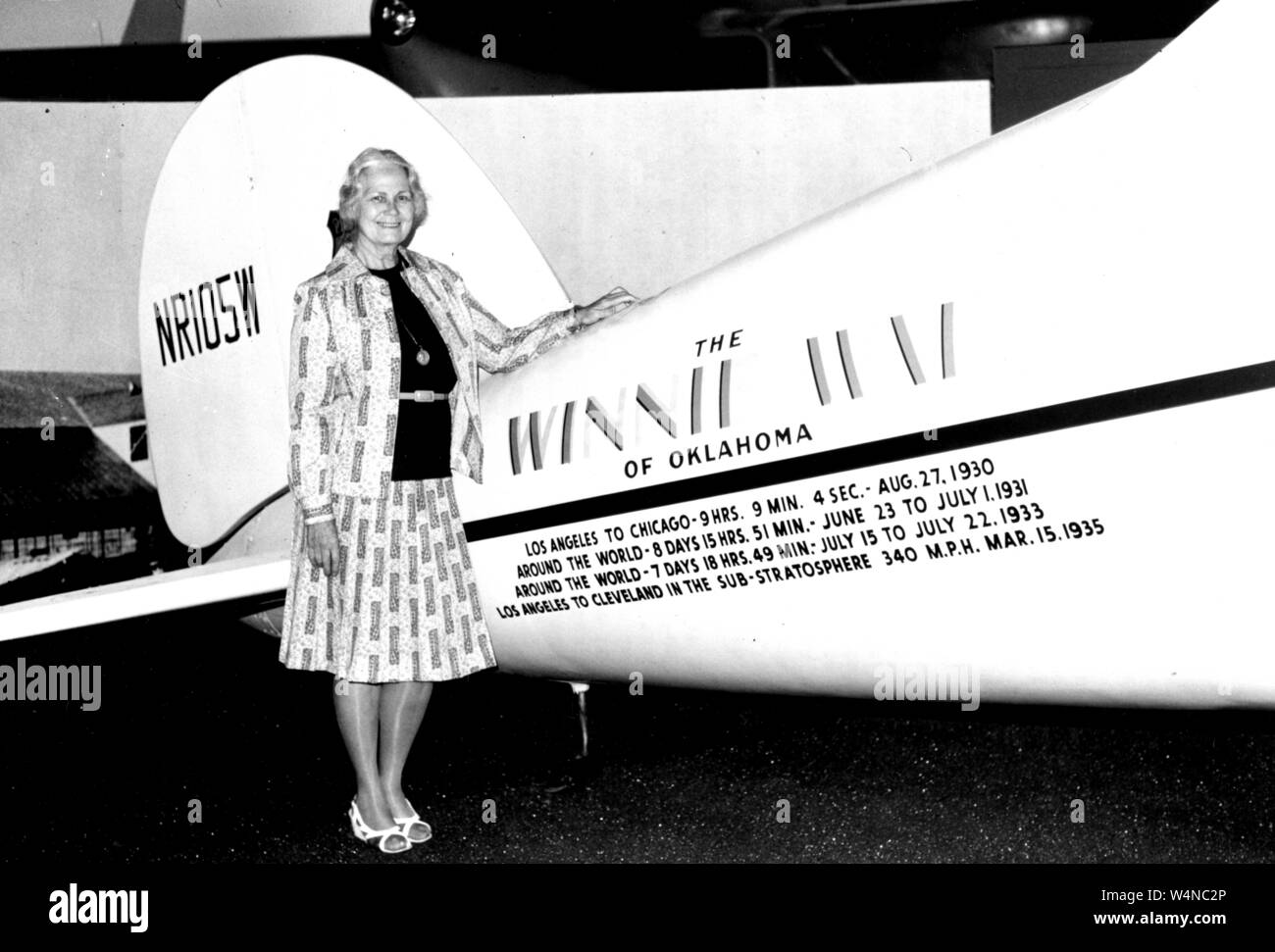 Fay Gillis Brunnen, eine amerikanische Pioneer aviator, globe-trotting Journalist und ein Sender, stellt neben dem Winnie Mae Ebene im National Air und Space Museum, Washington, District of Columbia, 1976. Mit freundlicher Genehmigung der Nationalen Luft- und Raumfahrtbehörde (NASA). () Stockfoto