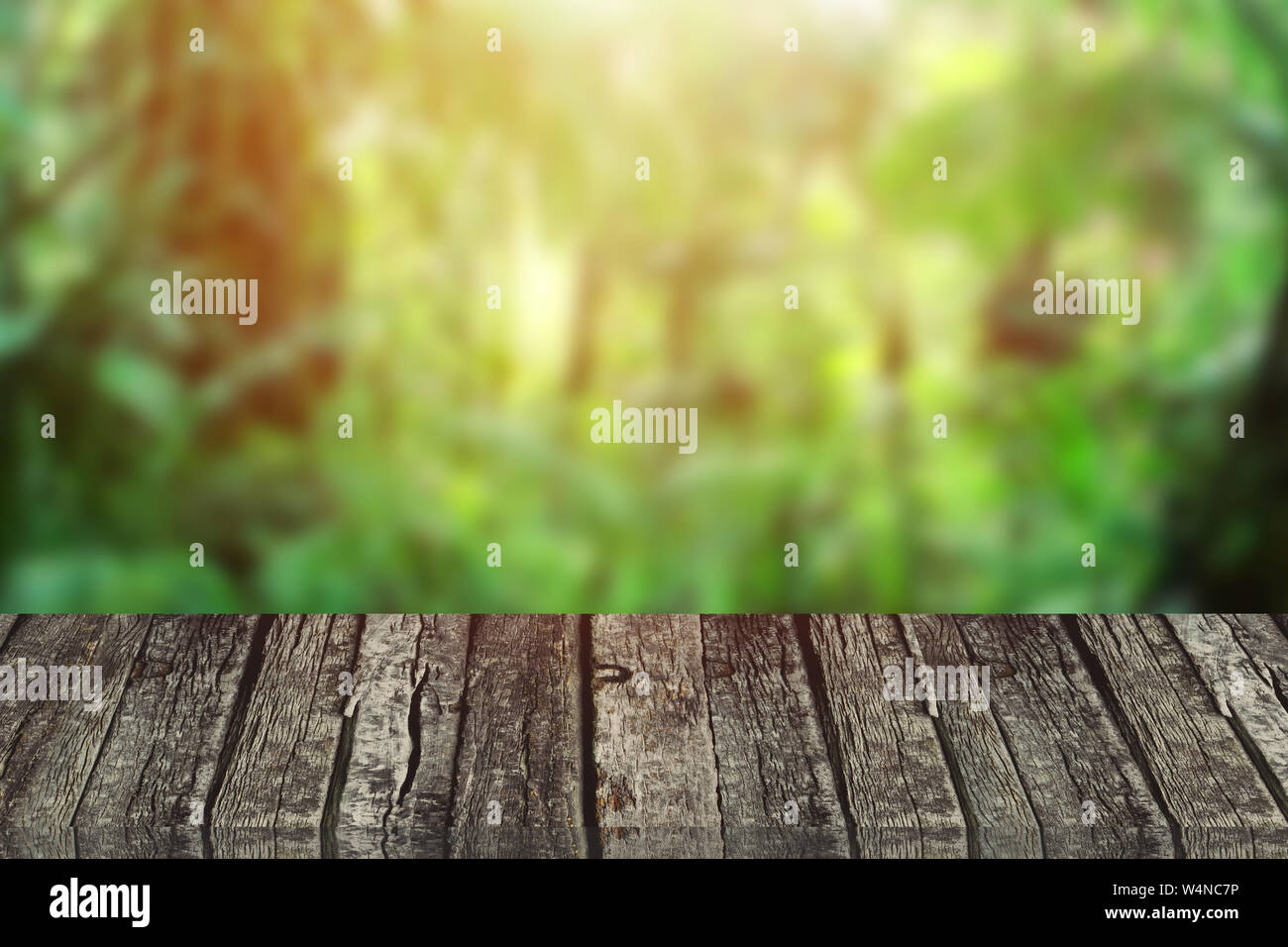 Blur grüne Natur Wald mit hölzernen Tischplatte Vordergrund für Werbung Hintergrund Stockfoto