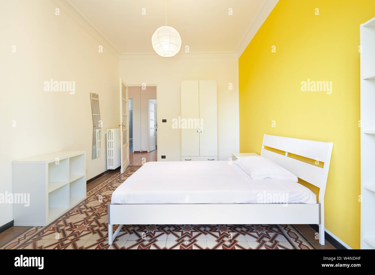 Renovierte Schlafzimmer in der Wohnung zum Mieten mit weißen und gelben Wänden Stockfoto