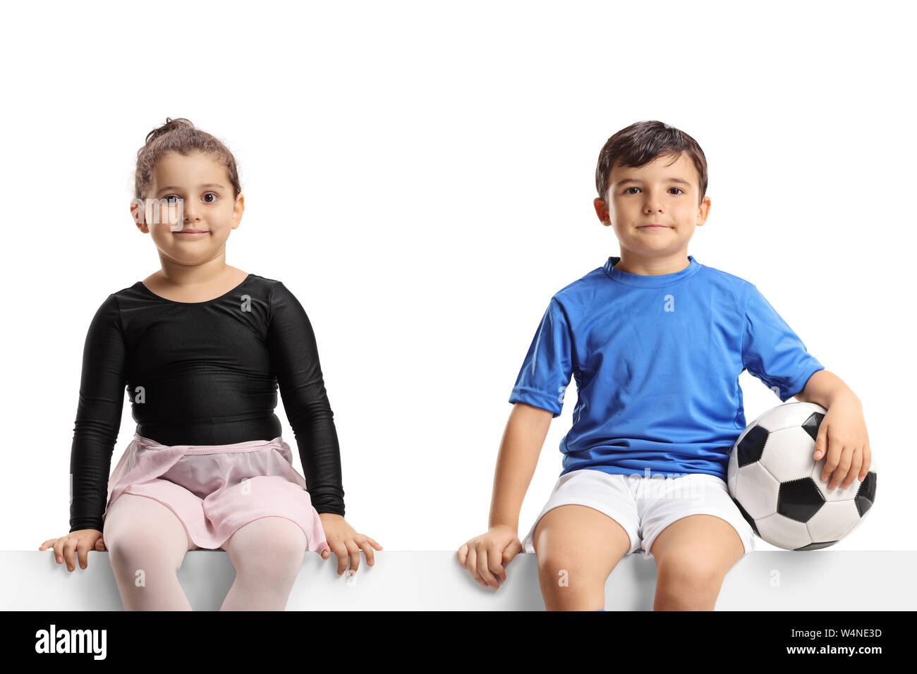 Kleine Ballerina Mädchen und einen kleinen Fußballer sitzen auf einem Panel, und wenn man die Kamera auf weißem Hintergrund Stockfoto