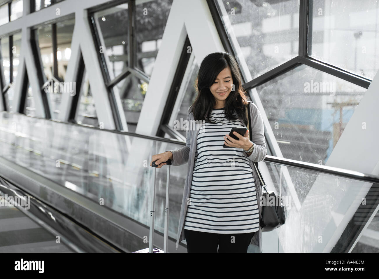 Schwangere Frauen in Asien siehe cellphones, wenn man zu Fuß durch die Rolltreppe Stockfoto Schwangere Frauen in Asien siehe cellphones, wenn man zu Fuß durch die Rolltreppe Stockfoto